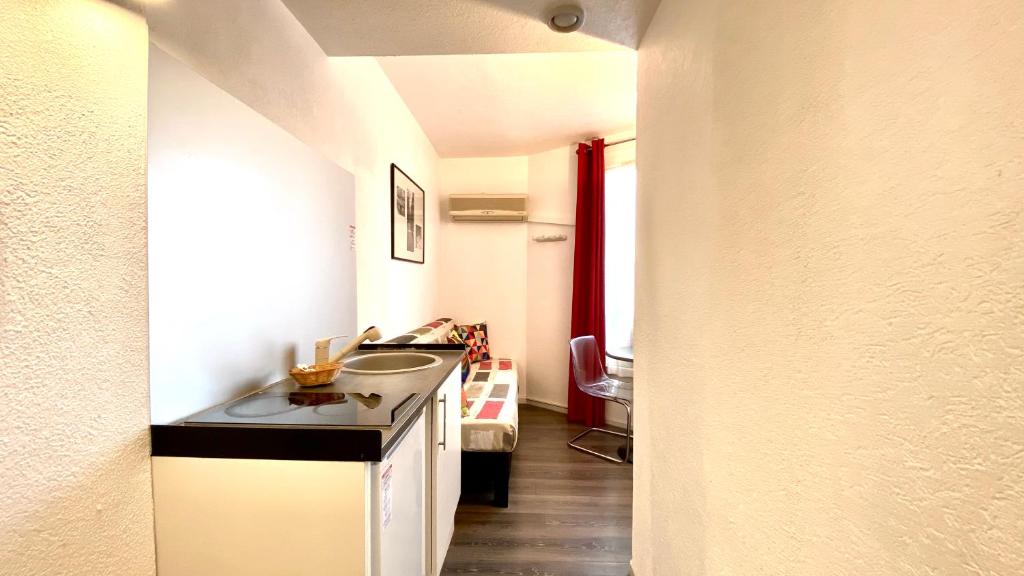 a small kitchen with a sink and a hallway at Boulogne Résidence Hotel in Boulogne-Billancourt