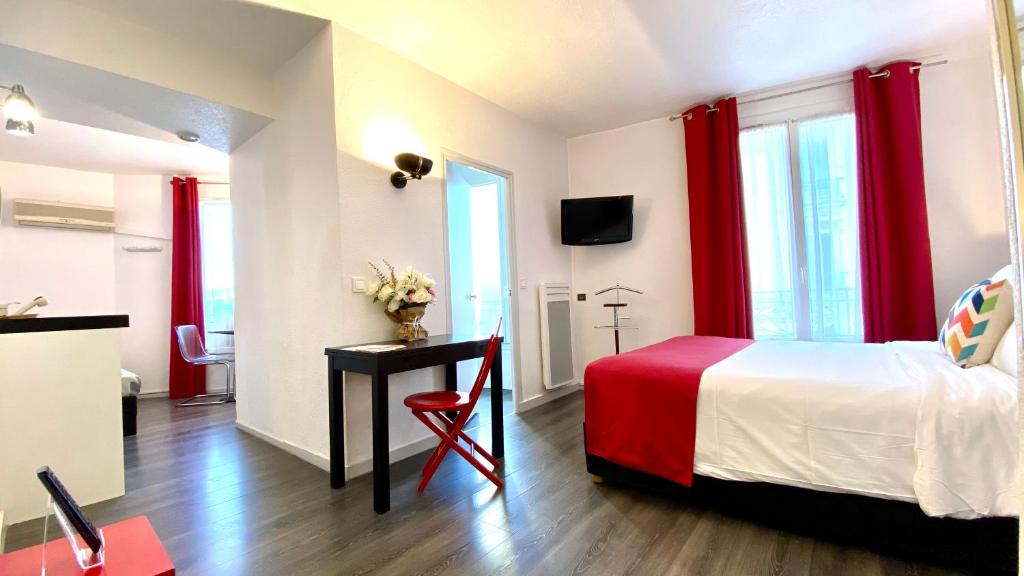 a bedroom with a bed with red curtains and a desk at Boulogne Résidence Hotel in Boulogne-Billancourt
