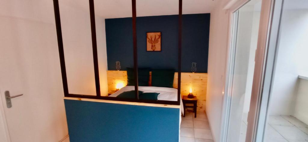 een kamer met een slaapkamer met een bed en een spiegel bij Brit's Studio in Talange