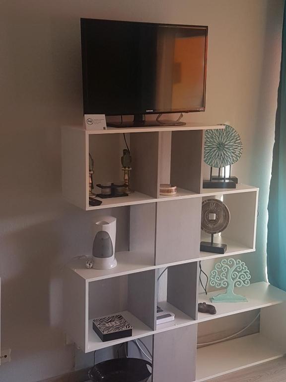 a white book shelf with a television on it at PLAYA LAS VISTAS LOFT in Los Cristianos