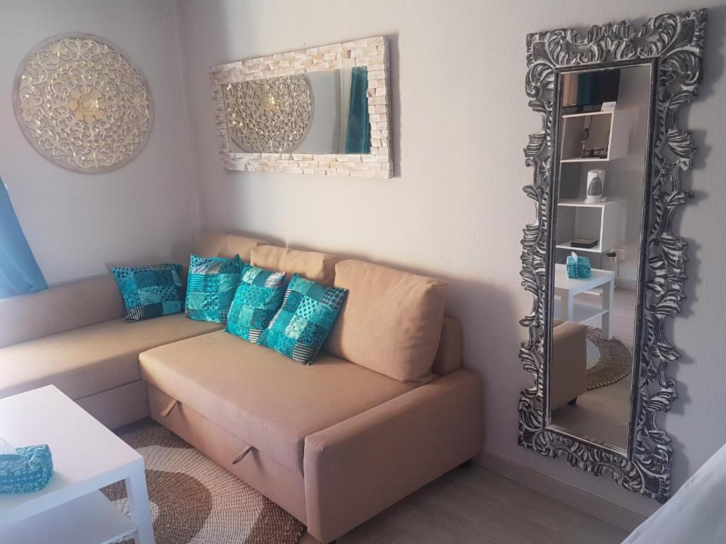 a living room with a couch and a mirror at PLAYA LAS VISTAS LOFT in Los Cristianos