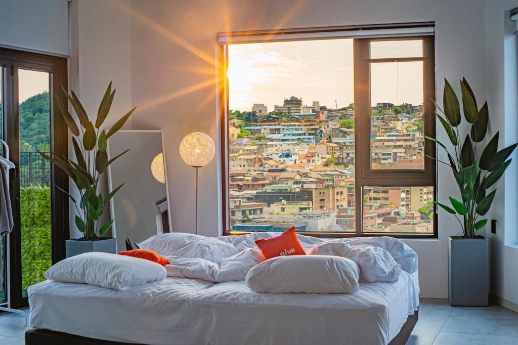 Glue Hotel في سول: غرفة نوم بسرير مع اطلالة على المدينة