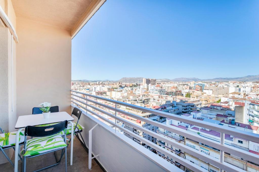 een balkon met een tafel en stoelen en een stad bij Beach Suite, city & mountain view in Alicante