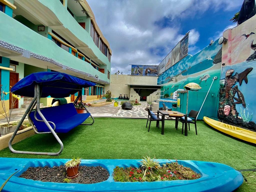 eine Terrasse mit Stühlen, einem Sonnenschirm und einem Tisch in der Unterkunft Galápagos Eco Friendly in Puerto Baquerizo Moreno