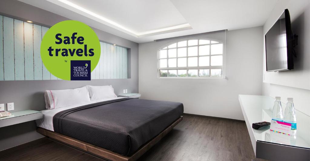 a bedroom with a bed and a sign that reads safe travels at Hotel MX congreso in Mexico City