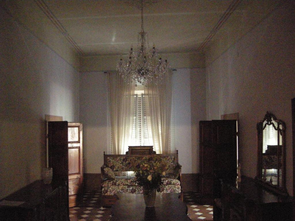 a living room with a couch and a chandelier at Portale dei Soli - Room & Breakfast in Rolo
