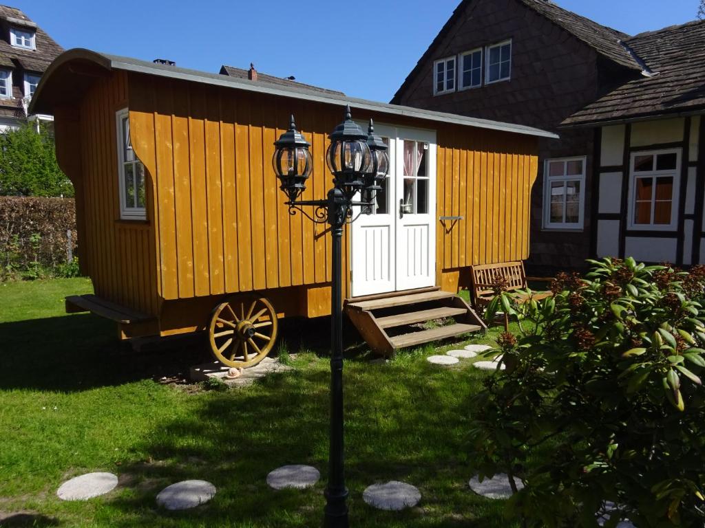 a tiny house with a white door and a street light at Zirkuswagen in Holzminden