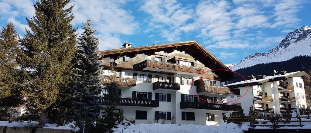 un bâtiment avec de la neige au sol et une montagne dans l'établissement Helvetia (388 Sr) 2. Stock, à Lenzerheide