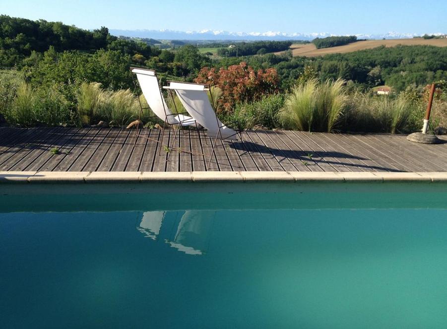 two chairs sitting next to a pool of water at L'Apouticayre in Montaut
