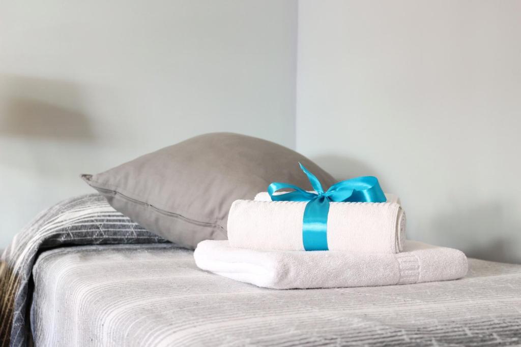 una pila de toallas con un lazo azul en una cama en b&b La Murina en Messina