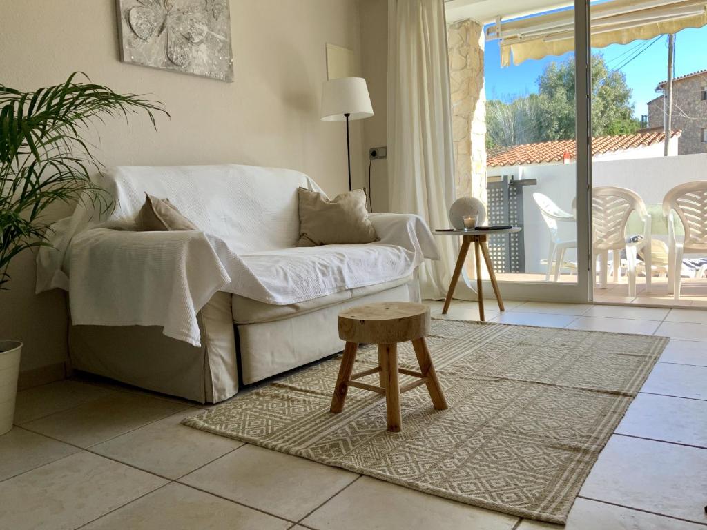 ein Wohnzimmer mit einem weißen Sofa und einem Stuhl in der Unterkunft Apartament Neàpolis 2 in Sant Martí d’Empúries