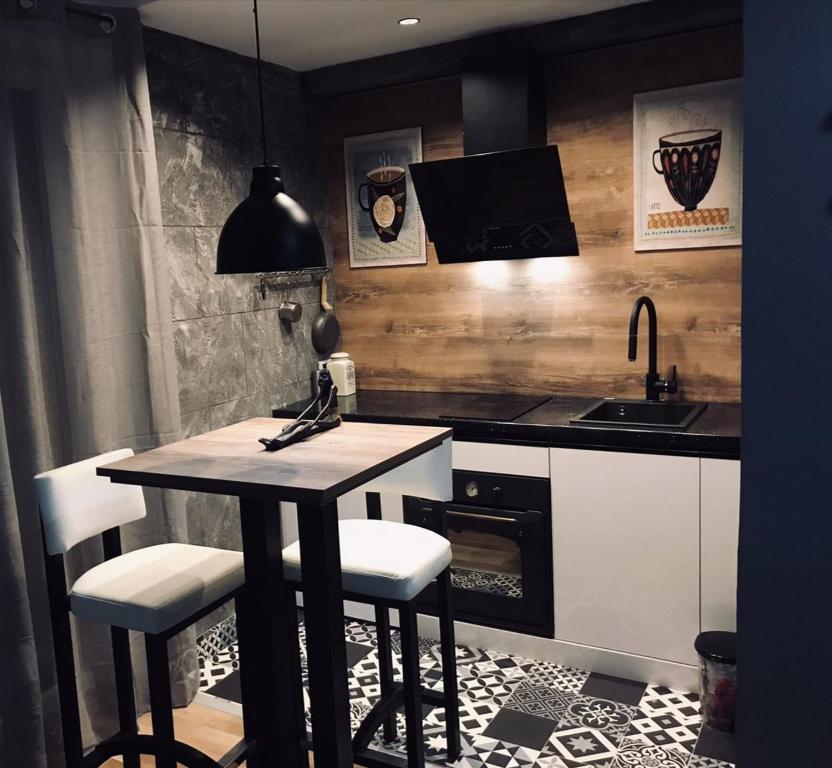 cocina con mesa, sillas y fregadero en Bubinga, en Kruševac