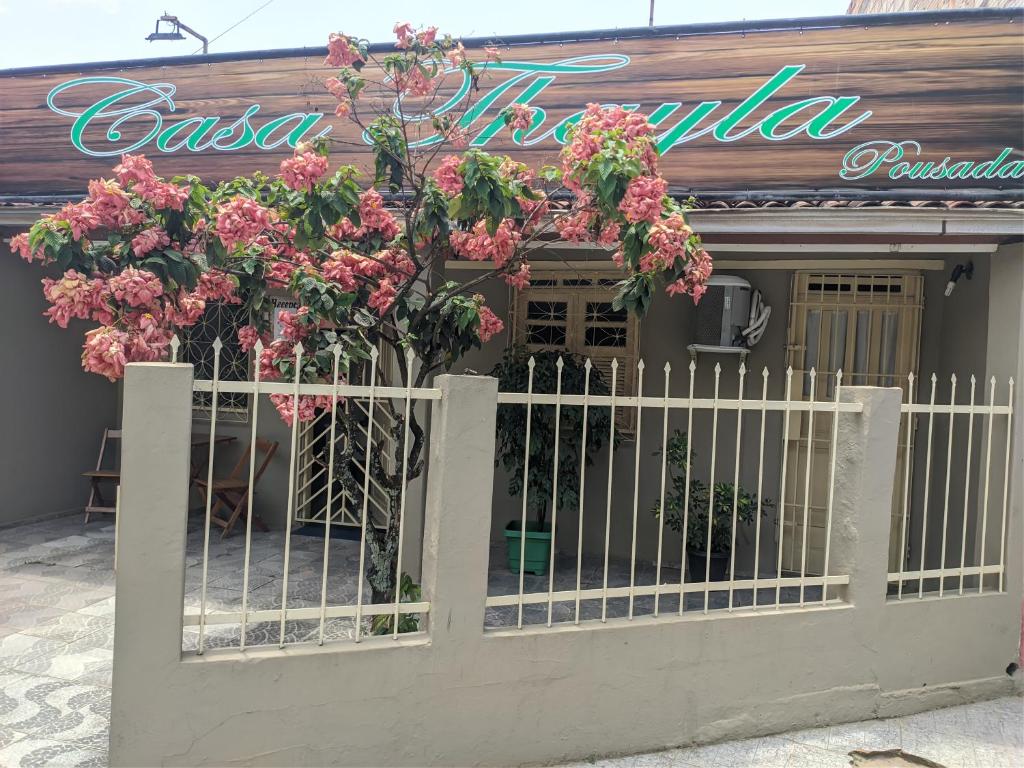 una puerta frente a un restaurante con flores rosas en Casa Thayla Pousada, en Itacaré