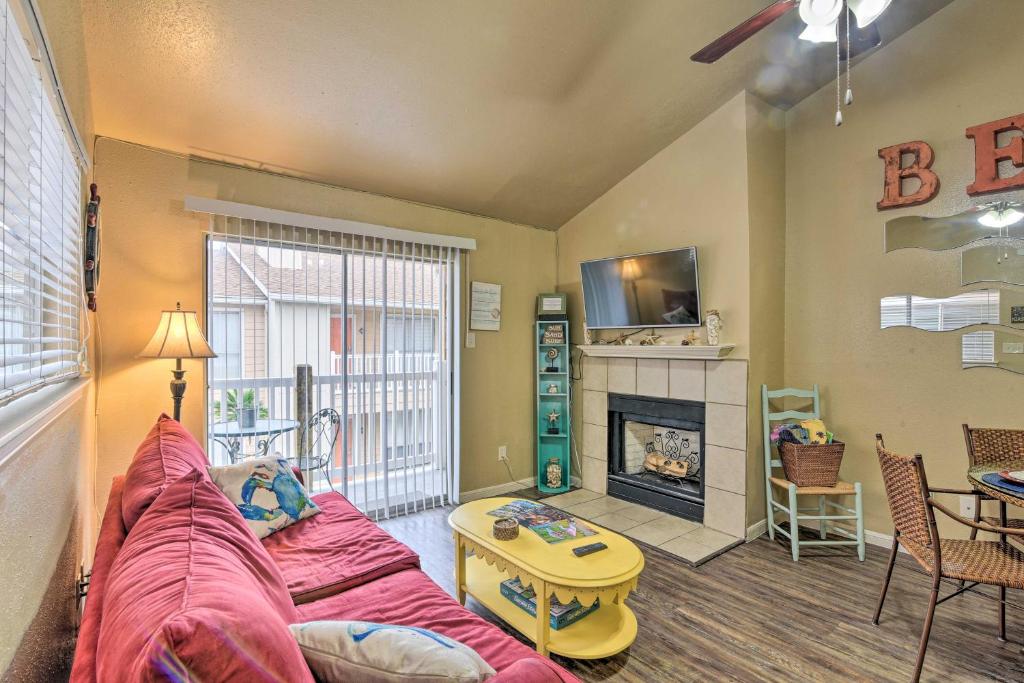 a living room with a couch and a fireplace at Romantic Galveston Retreat Bay View, Pool Access! in Galveston