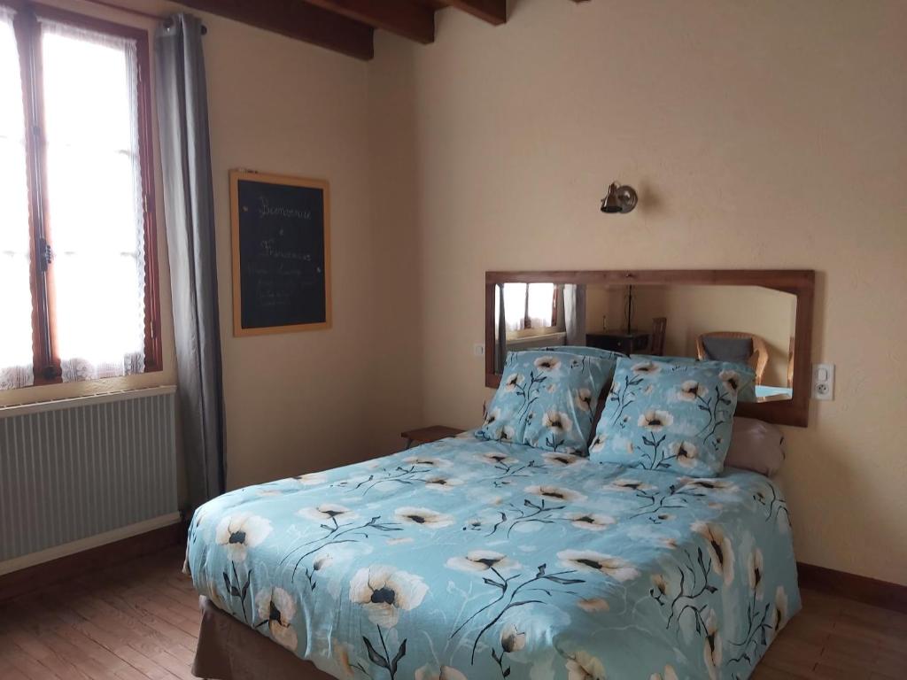 a bedroom with a bed with a blue comforter at Ô miroir... sans détour dis-moi tout de ce séjour in Francescas