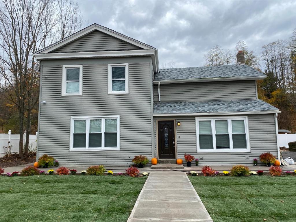 a gray house with a driveway in front of it at Holly Lodge - Ski Windham Hunter Catskills in Prattsville