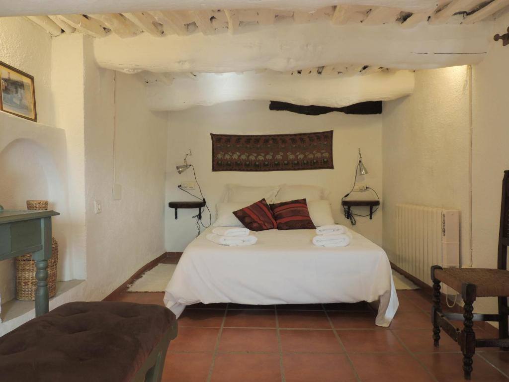 a bedroom with a bed with two towels on it at Casa La Romanilla in Capileira