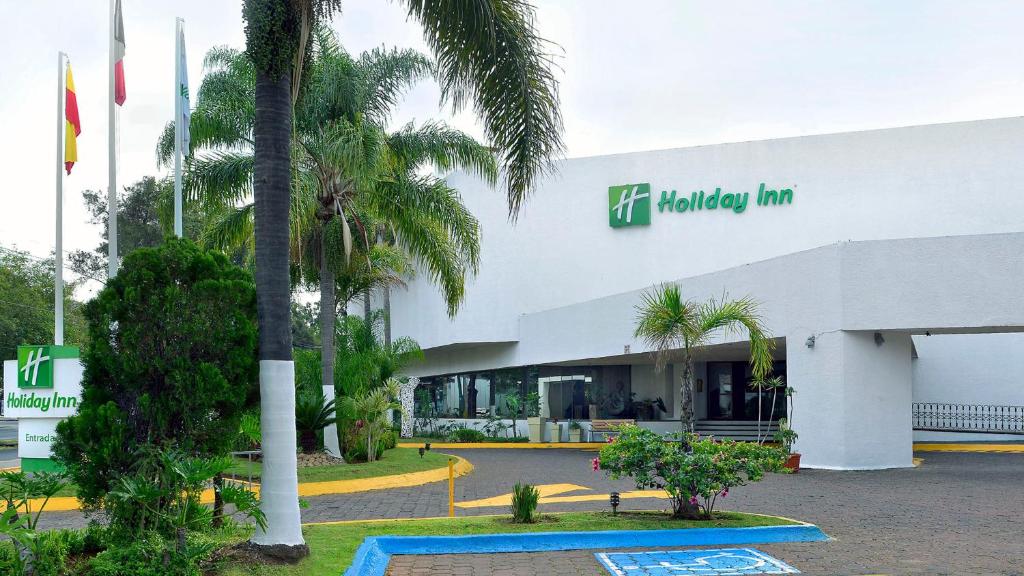 a building with a palm tree in front of it at Holiday Inn Morelia, an IHG Hotel in Morelia