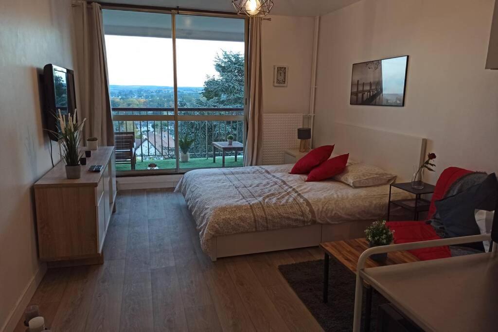 a bedroom with a bed and a large window at Un petit paradis pour se détendre et se ressourcer in Montrichard