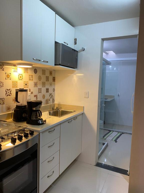 uma cozinha com um lavatório e um fogão forno superior em Moderno e pratico apt de dois quartos em Stella Maris em Salvador