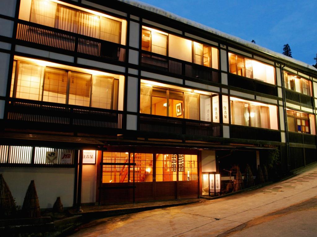 Sumiyosiya Ryokan في نوزاوا أونسن: مبنى مضاء بنوافذ مضاءة في الليل