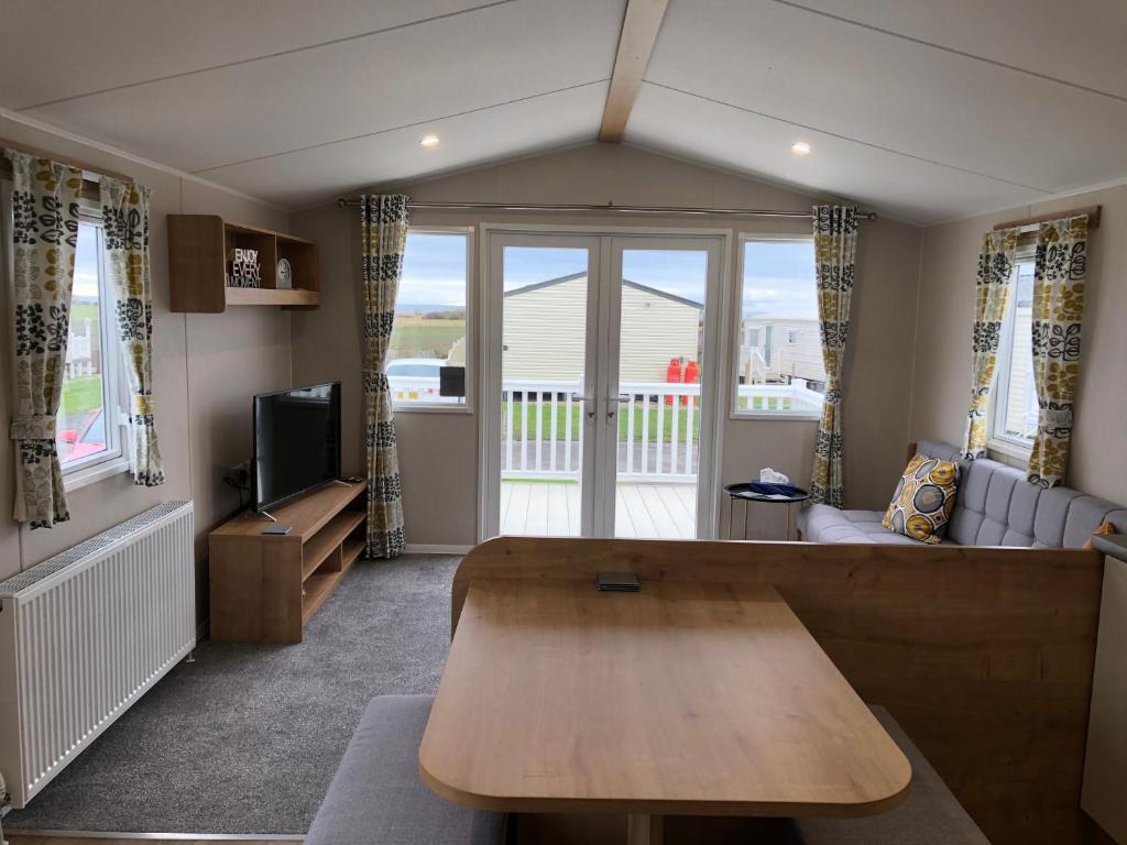 泰恩河畔新堡的住宿－Whitley bay 4 berth Luxury Caravan，客厅配有桌子和沙发