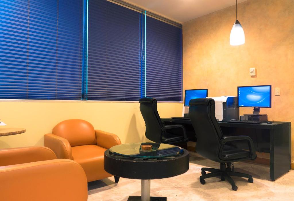 a waiting room with chairs and a desk with two monitors at Holiday Inn Monterrey-Parque Fundidora by IHG in Monterrey