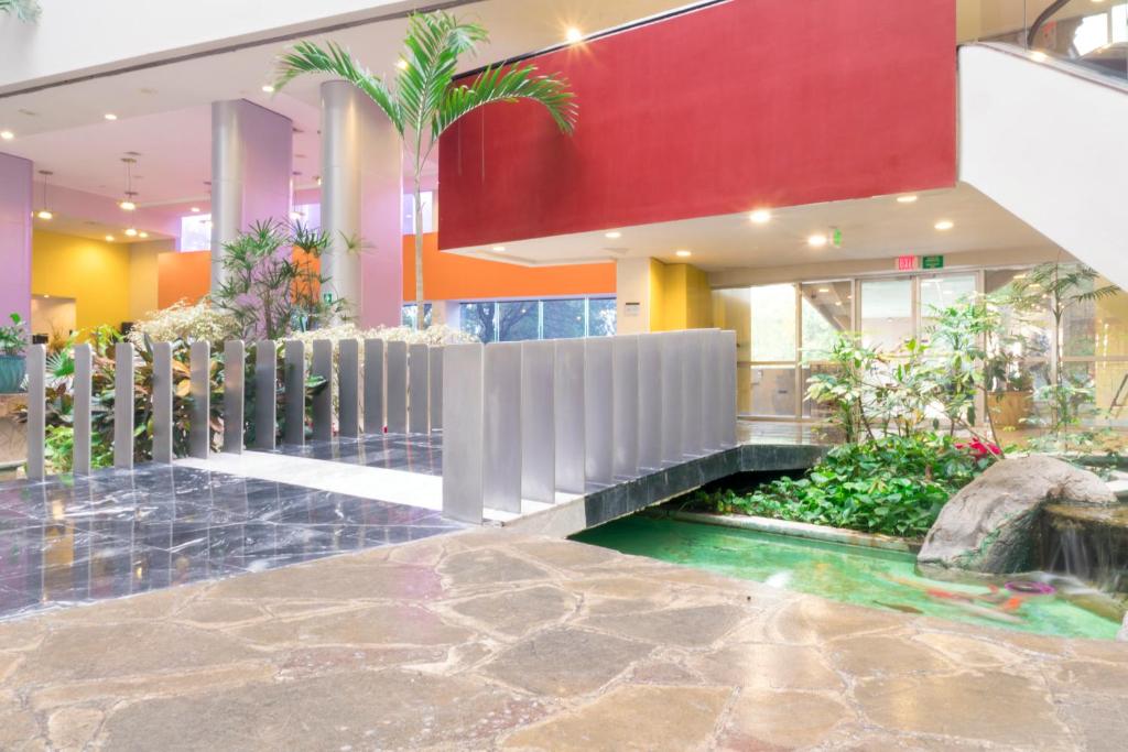 a building with a fountain in the middle of a lobby at Holiday Inn Monterrey-Parque Fundidora by IHG in Monterrey