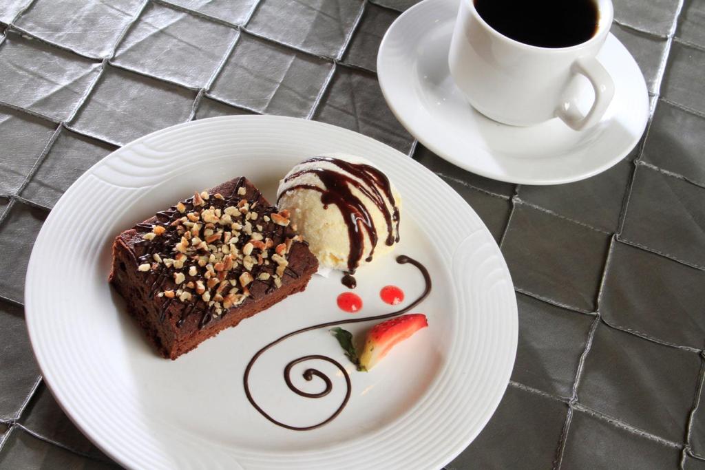 a plate with a piece of cake and a cup of coffee at Holiday Inn Monterrey-Parque Fundidora by IHG in Monterrey