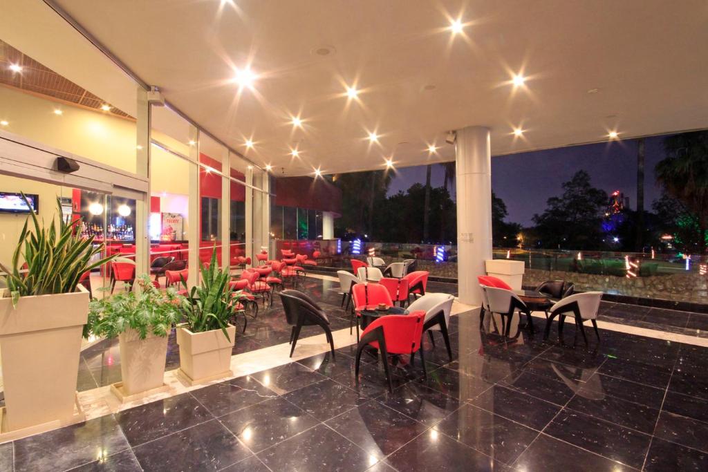 a restaurant with tables and chairs and lights at Holiday Inn Monterrey-Parque Fundidora by IHG in Monterrey