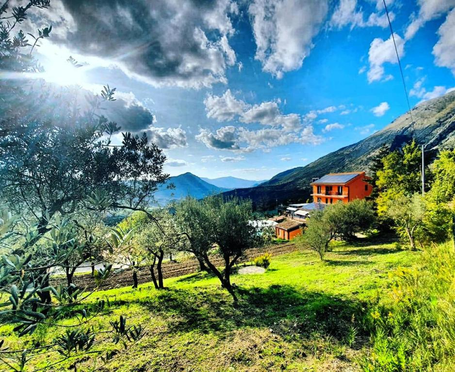 a house in a field with mountains in the background at Resort San Nicola - Restaurant and Wellness Fitness in Polizzi Generosa