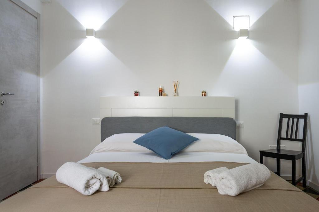 een slaapkamer met een bed met handdoeken erop bij Piazza Florio Rooms in Palermo