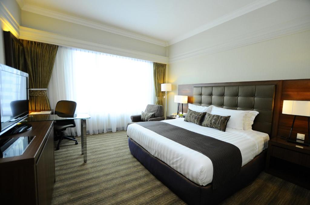 a hotel room with a bed and a television at The Katerina Hotel in Batu Pahat