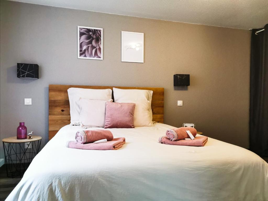 a bedroom with a large bed with pink towels on it at Carpe Diem - cote-montagnes in Oderen
