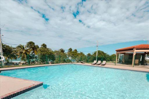 a large swimming pool with chairs and a building at Oceania Apartments at Arecibo 681 Ocean Drive in Arecibo