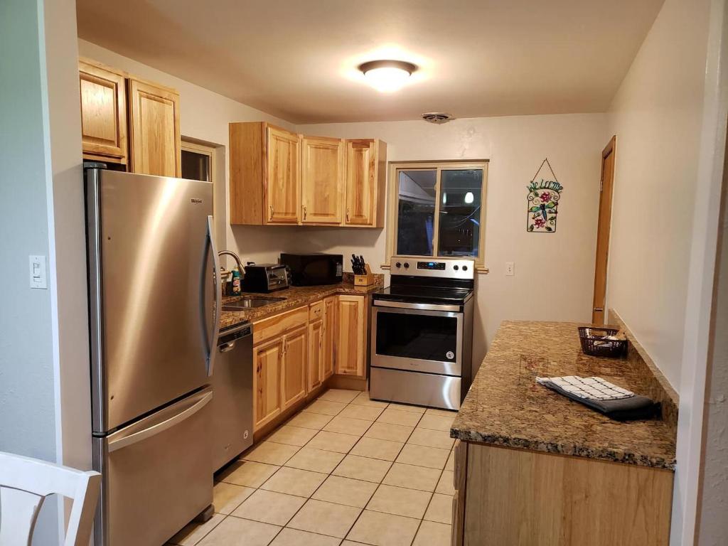 a kitchen with stainless steel appliances and wooden cabinets at HEART OF Denver*Sleeps 10 in Denver