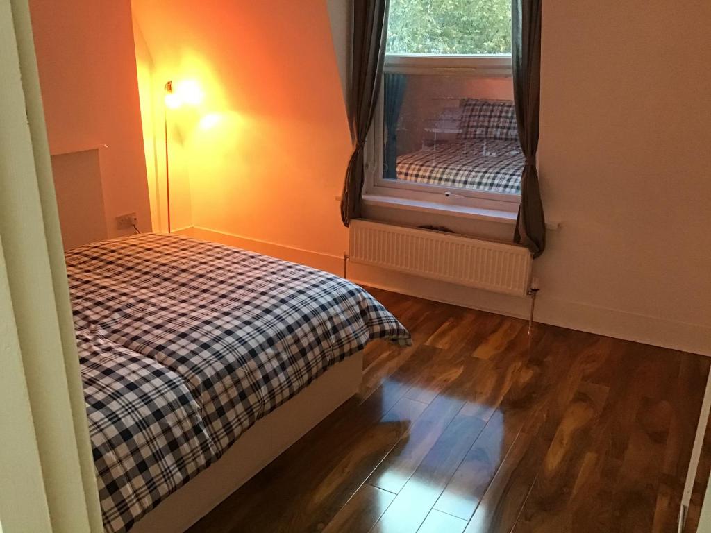 een kleine slaapkamer met een bed en een raam bij Residential Quarters, General Gordon Square in Londen