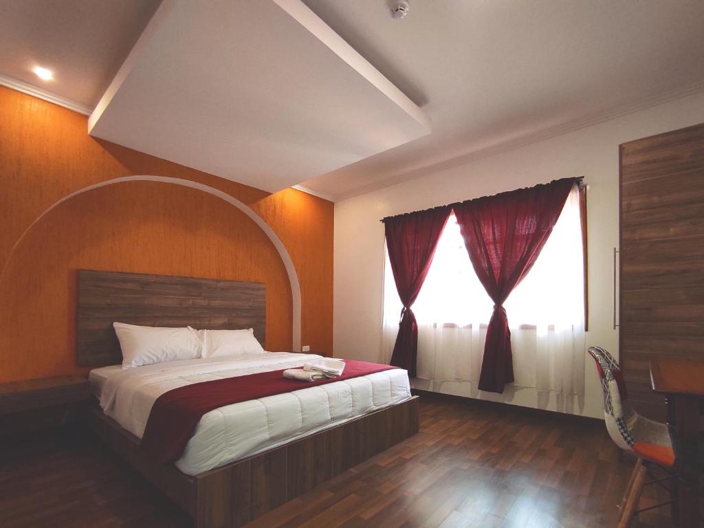 a bedroom with a large bed and a window at Hostal NIZZA in Cuenca