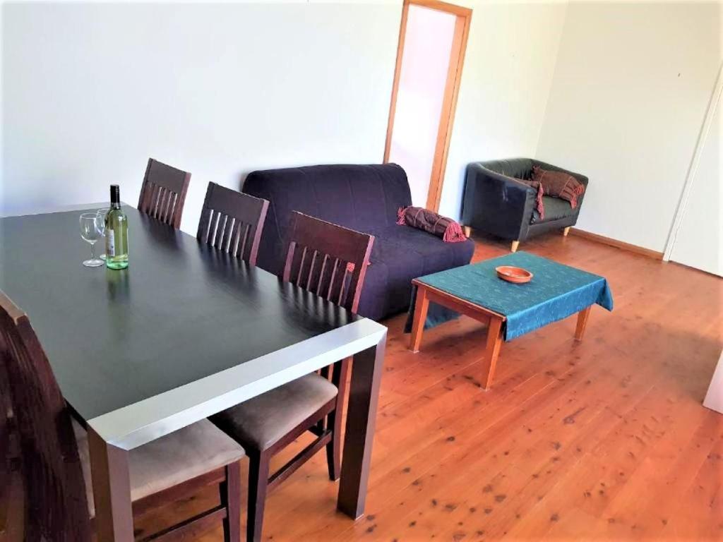 a living room with a table and a couch at Accommodation Sydney Frenchs Forest 3 bedroom House with Large Outdoor Entertainment Area and Onsite Parking in Frenchs Forest