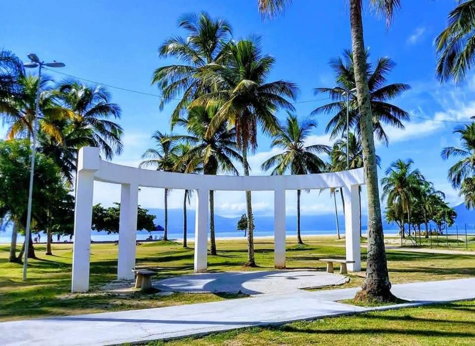 卡拉瓜塔图巴A Casa da Praia的棕榈树公园中的白色拱门