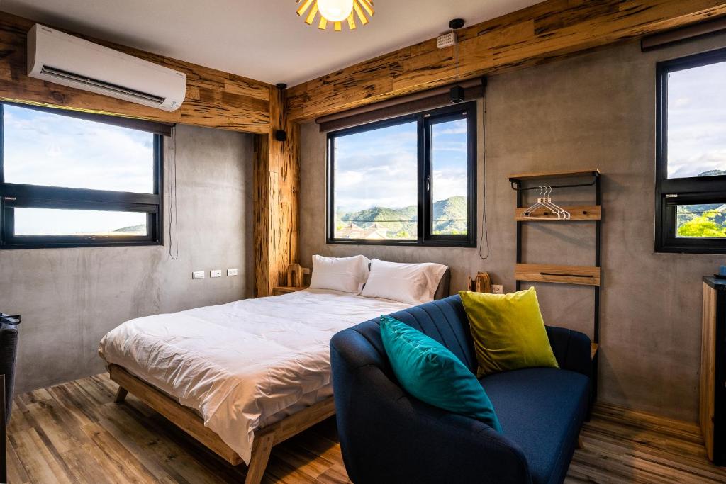 ein Schlafzimmer mit einem Bett, einem Sofa und Fenstern in der Unterkunft 似禾苑民宿 Siheyuan Homestay in Sanxing Township