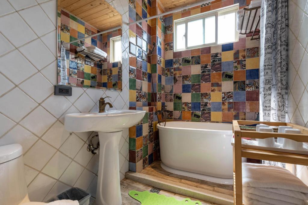 a bathroom with a tub and a sink and a bath tub at Sheep House B&amp;B in Ji&#39;an