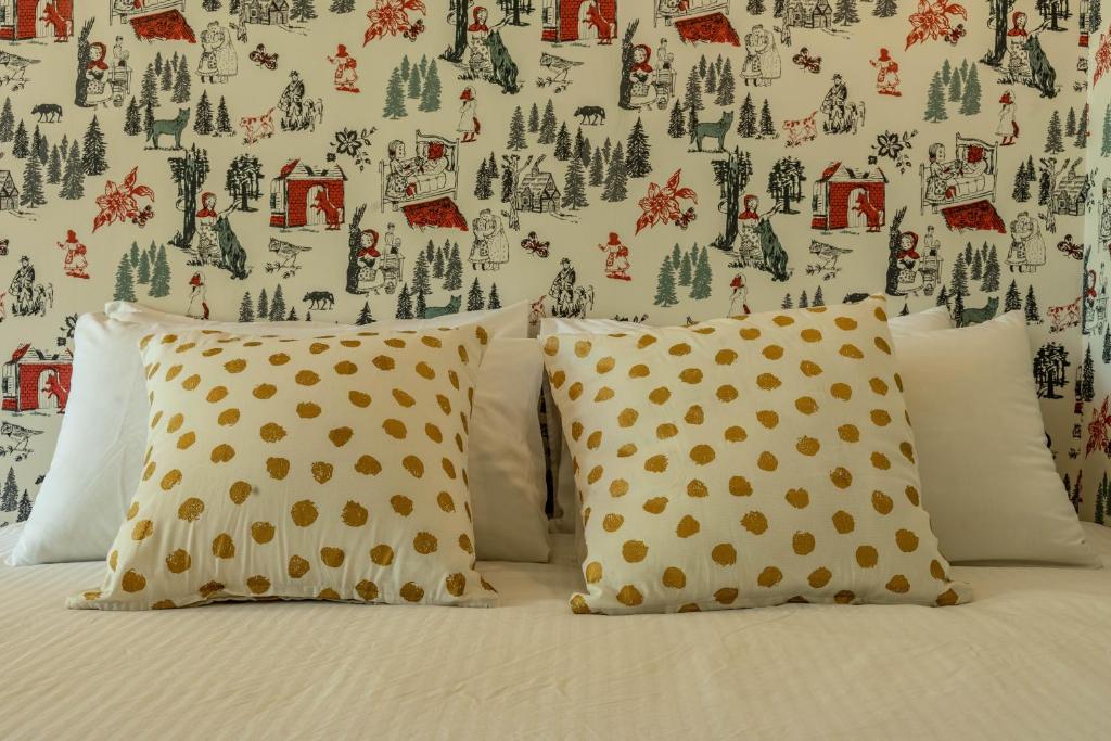 a bed with two pillows and a wallpaper with trees at Sheep House B&amp;B in Ji&#39;an