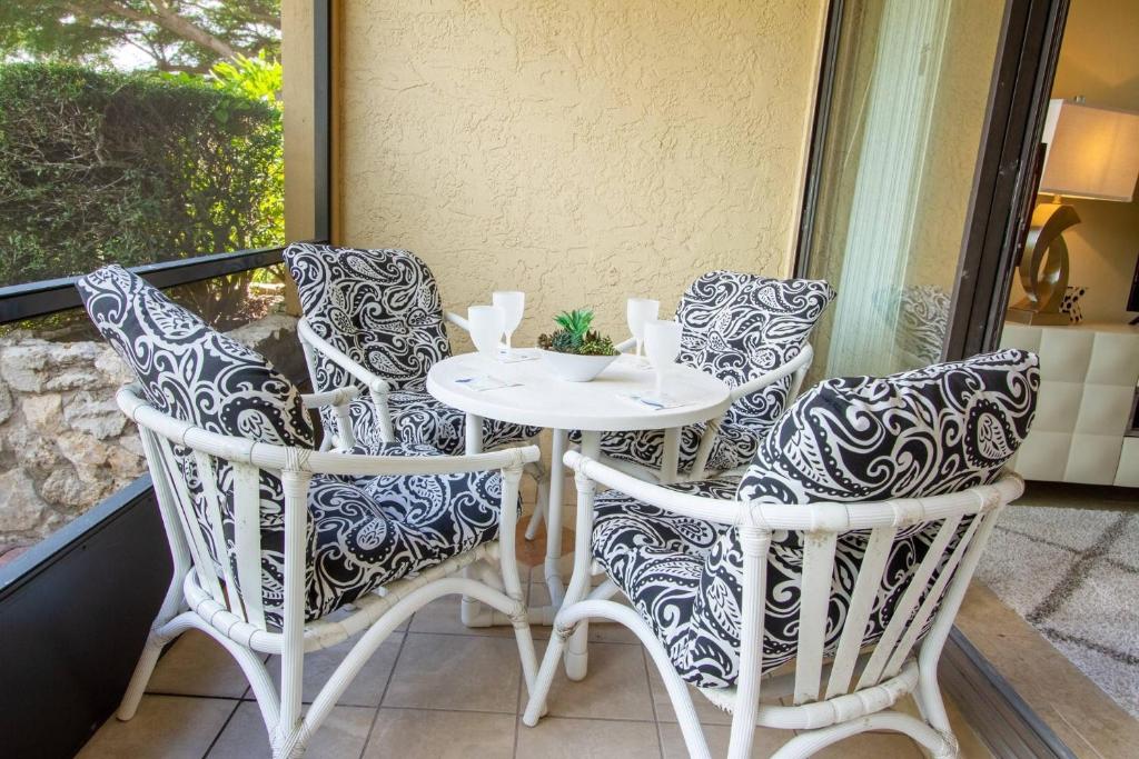 a white table and chairs on a balcony at Park Shore Resort, 1st Floor, Bldg. A in Naples