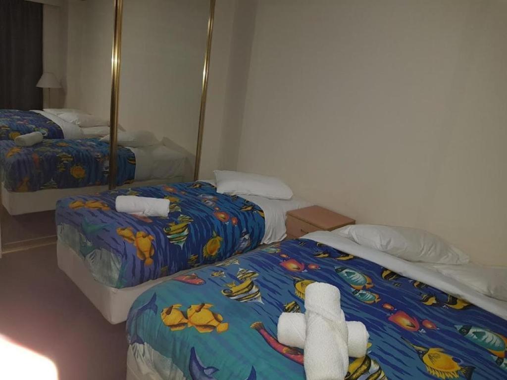 1 dormitorio con 2 camas con animales de peluche en Accommodation Sydney - Kent Street, en Sídney