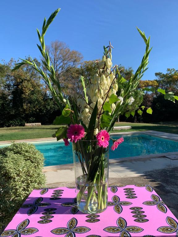 un jarrón de flores sobre una mesa con un mantel en Le Jardin de LaCoste, en Narbona