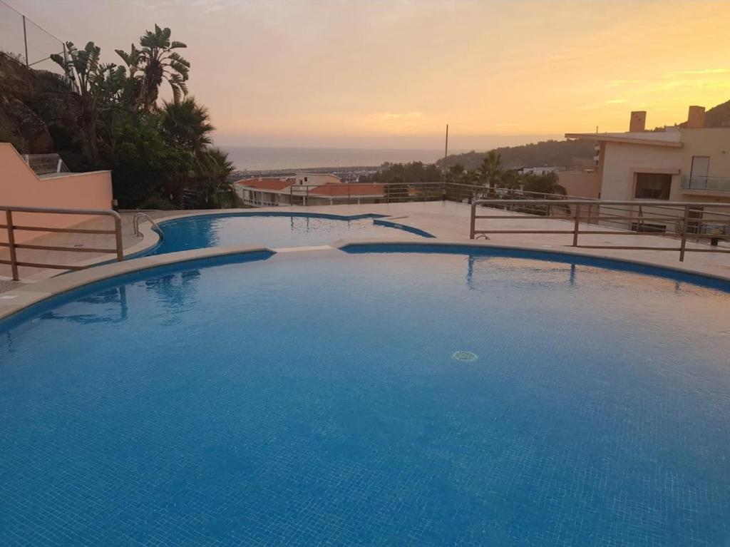 a large blue swimming pool on top of a house at Appartement Quinta de Palames Sesimbra in Sesimbra
