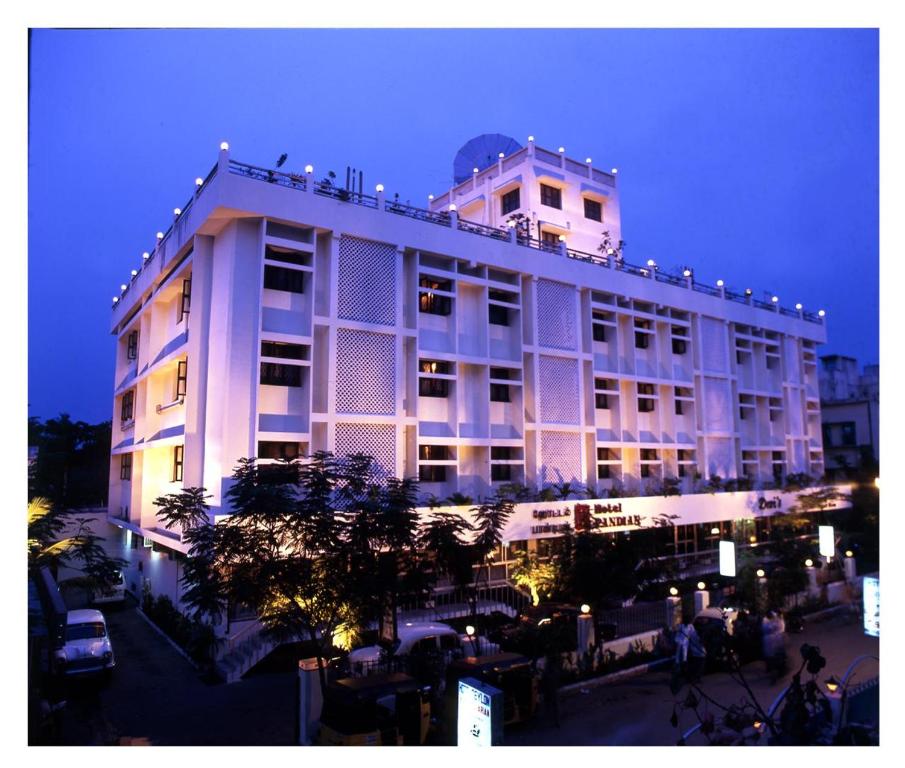 a large white building with people standing outside of it at Hotel Pandian in Chennai