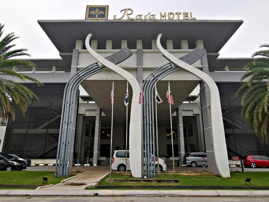 ein Hotel mit zwei großen Metallskulpturen davor in der Unterkunft Raia Hotel & Convention Centre Terengganu in Kuala Terengganu