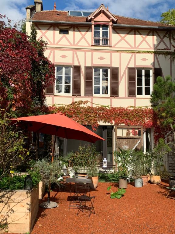 吉維尼的住宿－Le studio du botaniste，前面有桌子和雨伞的房子